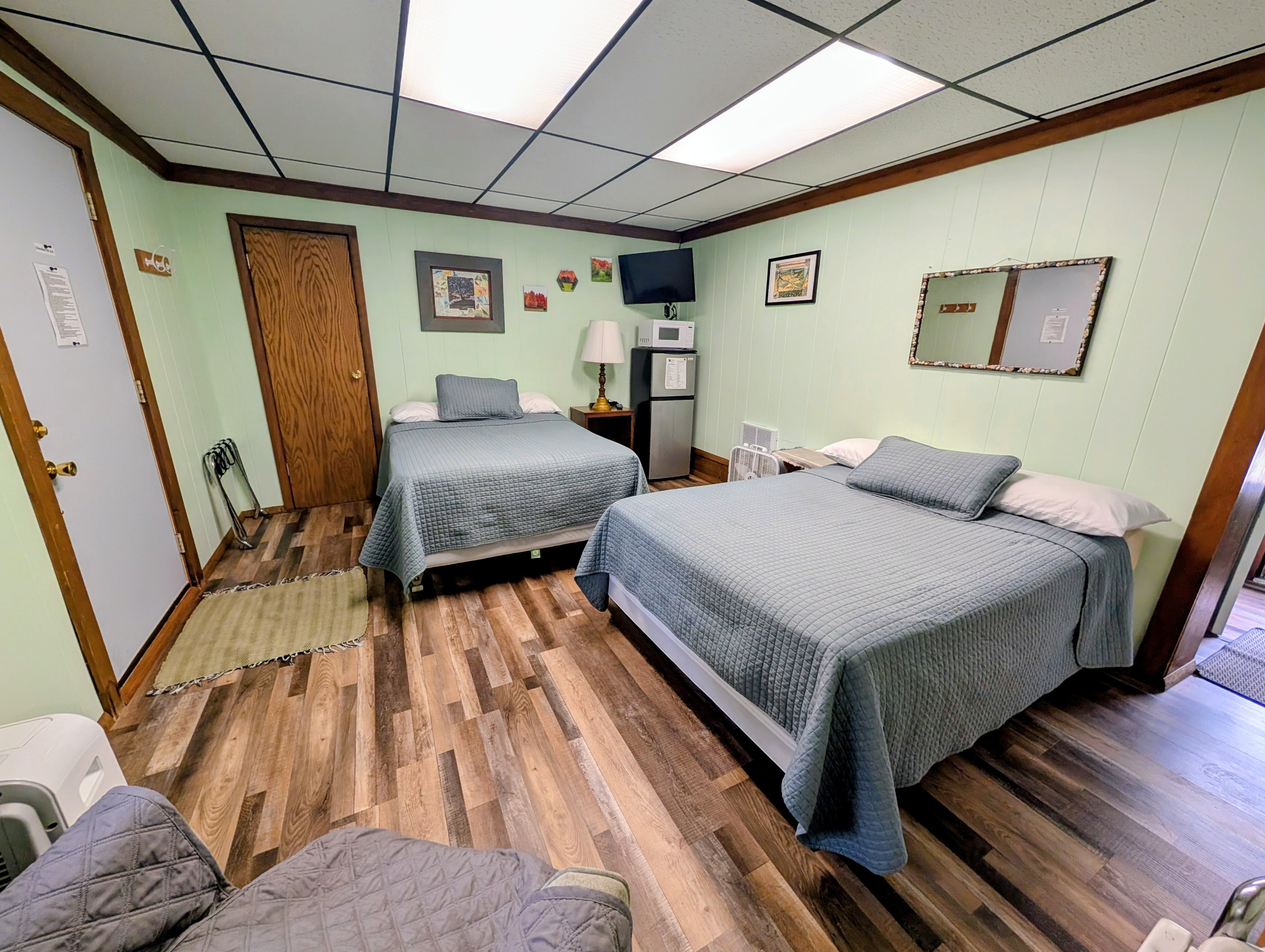 A cozy room featuring two beds, a small table, and a TV.